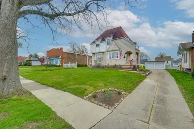 a white house with a red roof at Inviting Vacation Home 2 Mi to Mill Creek Falls! in Garfield Heights