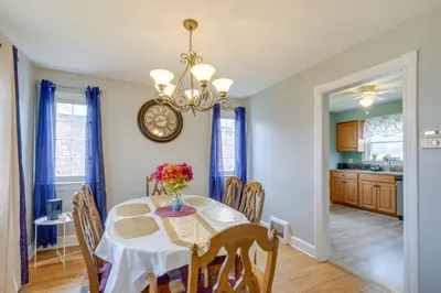 a dining room with a table and chairs and a clock at Inviting Vacation Home 2 Mi to Mill Creek Falls! in Garfield Heights