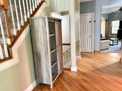 a wooden cabinet in a living room with stairs at Nice Home in Hudson in Hudson