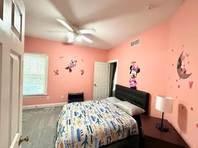 a bedroom with pink walls and a bed and a ceiling fan at Nice Home in Hudson in Hudson
