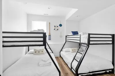 two bunk beds in a room with white walls at Lakeside, Water-view, 7 miles to Ark, 4BR for 14 in Williamstown