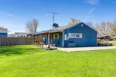 a blue house sitting on top of a yard at Waterfront Port Clinton Cottage with Fire Pit! in Port Clinton