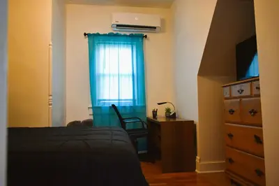 a bedroom with a bed and a dresser and a window at Downtown Lima 1 Bdrm Haven! in Lima