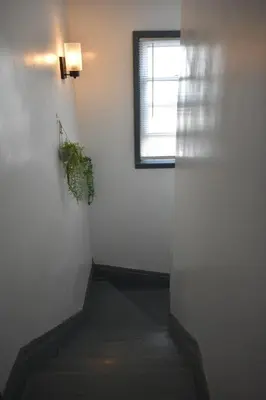 a stairway with a window and a plant at Downtown Lima 1 Bdrm Haven! in Lima