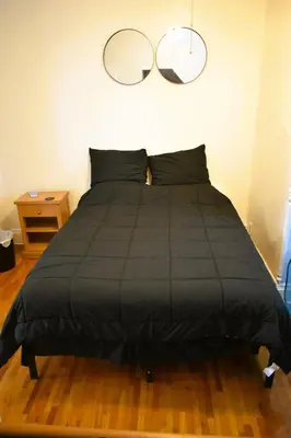 a bedroom with a black bed with two mirrors on the wall at Downtown Lima 1 Bdrm Haven! in Lima