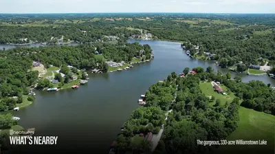 an aerial view of a lake with houses and trees at The Lodges at Eden Reserve - Pet Friendly Cabins Near Ark in Williamstown