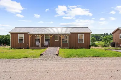 a small wooden house with a gravel driveway at Block of 7 Lodges at Eden Reserve - For Groups in Williamstown