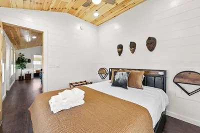 a bedroom with a bed and two masks on the wall at Block of 7 Lodges at Eden Reserve - For Groups in Williamstown