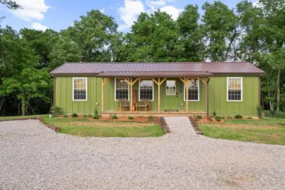 a green tiny house with a gravel driveway at Block of 5 Lodges at Eden Reserve - For Groups in Williamstown