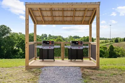 a gazebo with two burners in a field at The Lodges at Eden Reserve - Cabins Near Ark in Williamstown
