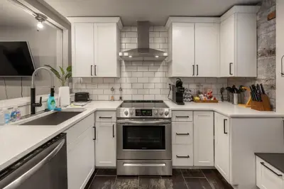 a kitchen with white cabinets and a stainless steel oven at 1BR Apt, Minutes to Downtown Cincy, Stadiums, Bars in Ludlow