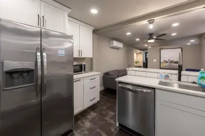 a kitchen with a stainless steel refrigerator and white cabinets at 1BR Apt, Minutes to Downtown Cincy, Stadiums, Bars in Ludlow