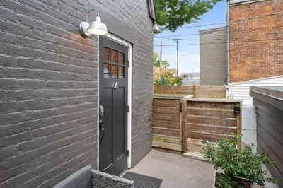a door in a brick wall with a fence at Close to Stadiums, Downtown Cincy, & more, 1BR Apt in Ludlow