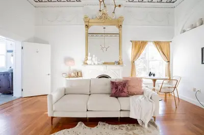a living room with a white couch and a fireplace at Walk to Stadiums & Downtown, Jet Tub, Historic Apt in Covington