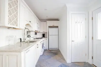 a white kitchen with a sink and a refrigerator at Walk to Stadiums & Downtown, Jet Tub, Historic Apt in Covington