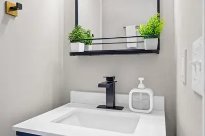 a bathroom with a white sink and a mirror at 6 Min to Ark, Free Covered Parking, Deck and Grill in Williamstown