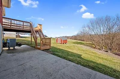 a wooden ramp leading to a house with a red barn at 6 Min to Ark, Free Covered Parking, Deck and Grill in Williamstown