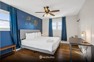 a bedroom with a bed with blue walls and a ceiling fan at 6 Min to Ark, Free Covered Parking, Deck and Grill in Williamstown