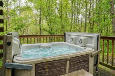 a hot tub on the back of a deck at Blue Rose Cabins - Cozy Cabin in Logan
