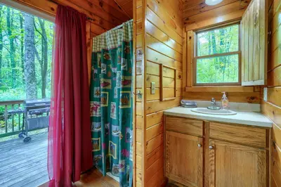a bathroom with a sink and a window in a cabin at Blue Rose Cabins - Cozy Cabin in Logan
