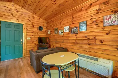 a living room with a couch and a table at Blue Rose Cabins - Cozy Cabin in Logan