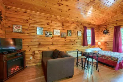 a bedroom with a bed and a table with a fireplace at Blue Rose Cabins - Cozy Cabin in Logan