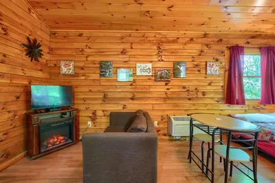 a living room with a fireplace in a log cabin at Blue Rose Cabins - Cozy Cabin in Logan