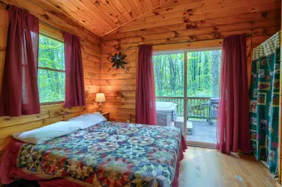 a bedroom with a bed in a log cabin at Blue Rose Cabins - Cozy Cabin in Logan