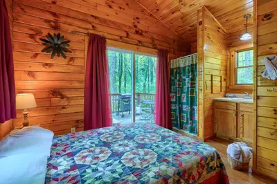 a bedroom with a bed in a log cabin at Blue Rose Cabins - Cozy Cabin in Logan