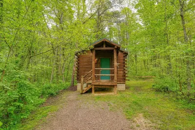 a wooden cabin in the middle of a forest at Blue Rose Cabins - Cupids Cabin in Logan
