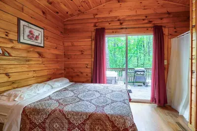 a bedroom with a bed in a log cabin at Blue Rose Cabins - Cupids Cabin in Logan