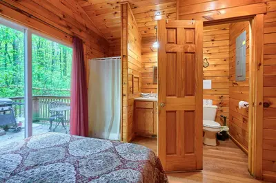 a bedroom with a bed in a wooden cabin at Blue Rose Cabins - Cupids Cabin in Logan