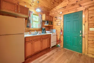 a kitchen with a green door and a refrigerator at Blue Rose Cabins - Cupids Cabin in Logan