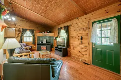 a living room with a green door and a couch at Blue Rose Cabins - Lincoln Log Cabin in Logan