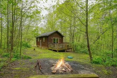a log cabin with a fire in front of it at Blue Rose Cabins - Lovebirds Cabin in Logan