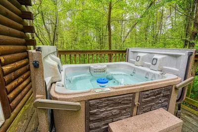 a hot tub on the deck of a cabin at Blue Rose Cabins - Lovebirds Cabin in Logan