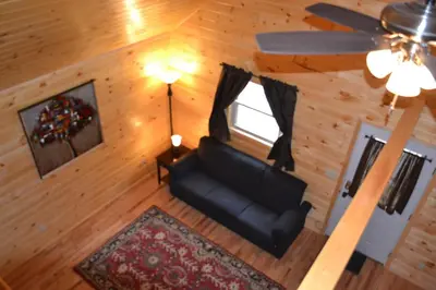 an overhead view of a living room with a couch and a window at Blue Rose Cabins - Naughty Pine Cabin in Logan
