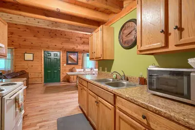 a kitchen with wooden cabinets and a counter top at Blue Rose Cabins - Oleander Cabin in Logan