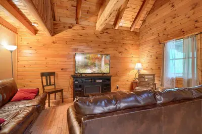 a living room with a leather couch and a fireplace at Blue Rose Cabins - Oleander Cabin in Logan