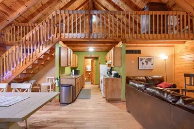 a large living room with a couch and a kitchen at Blue Rose Cabins - Oleander Cabin in Logan