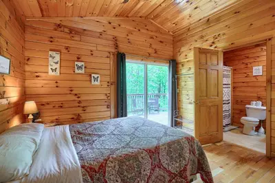 a bedroom with a bed in a log cabin at Blue Rose Cabins - Overlook Cabin in Logan
