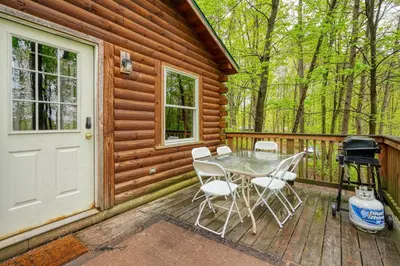 a wooden deck with a table and chairs and a grill at Blue Rose Cabins - Pine Ridge Cabin in Logan
