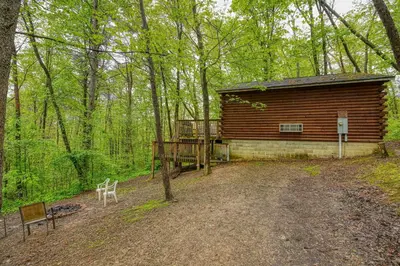 a log cabin in the woods with a bench at Blue Rose Cabins - Pine Ridge Cabin in Logan