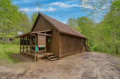 a large wooden cabin in the middle of the woods at Blue Rose Cabins - Pinecrest Cabin in Logan