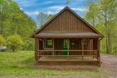 a small wooden house in the middle of a field at Blue Rose Cabins - Pinecrest Cabin in Logan