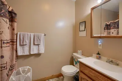 a bathroom with a toilet and a sink and a mirror at Blue Rose Cabins - Rosebud Cabin in Logan