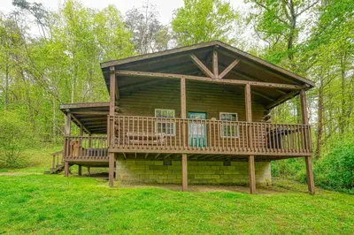 a log cabin with a porch and a deck at Blue Rose Cabins - Rosebud Cabin in Logan