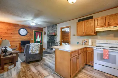 a kitchen with wooden cabinets and a stove top oven at Blue Rose Cabins - Rosebud Cabin in Logan