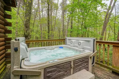 a hot tub on the deck of a house at Blue Rose Cabins - Sweet Dreams Cabin in Logan