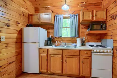 a kitchen with a white refrigerator and a sink at Blue Rose Cabins - Sweet Dreams Cabin in Logan